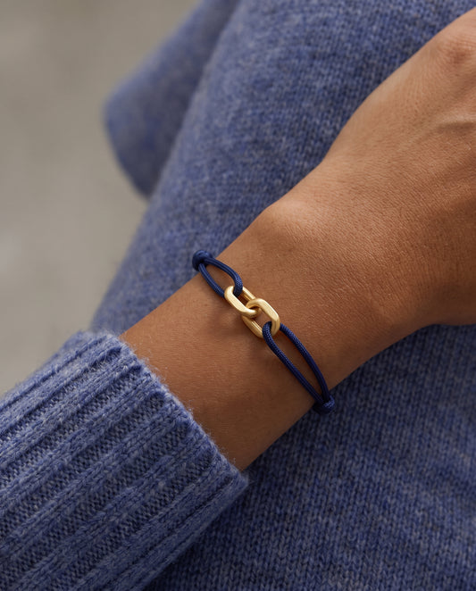 Link Bracelet in 14-karat solid gold on a navy cord, worn on the wrist