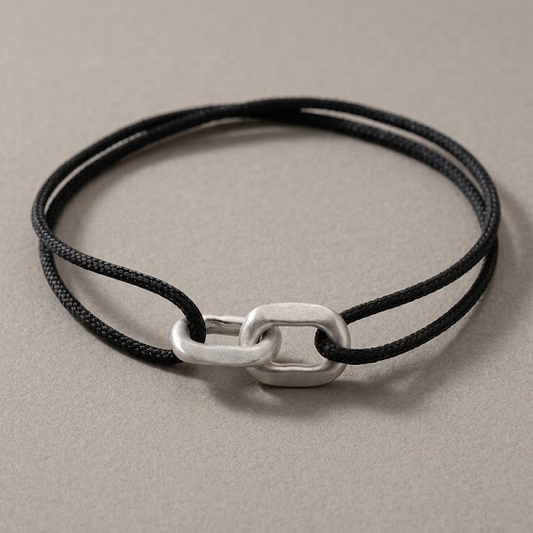 Link Bracelet in 925 silver on a black woven cord, laid flat