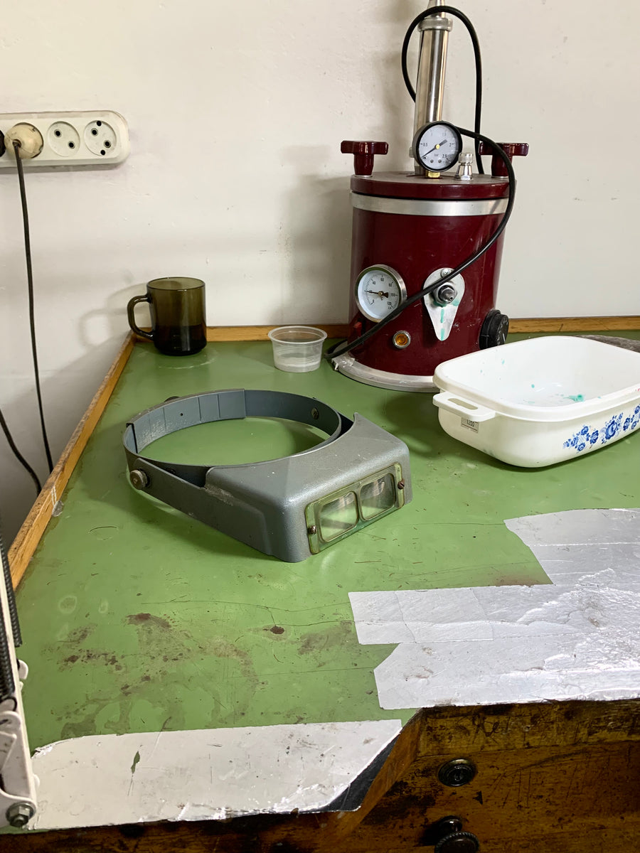 A jeweler’s bench with magnifying visor and tools