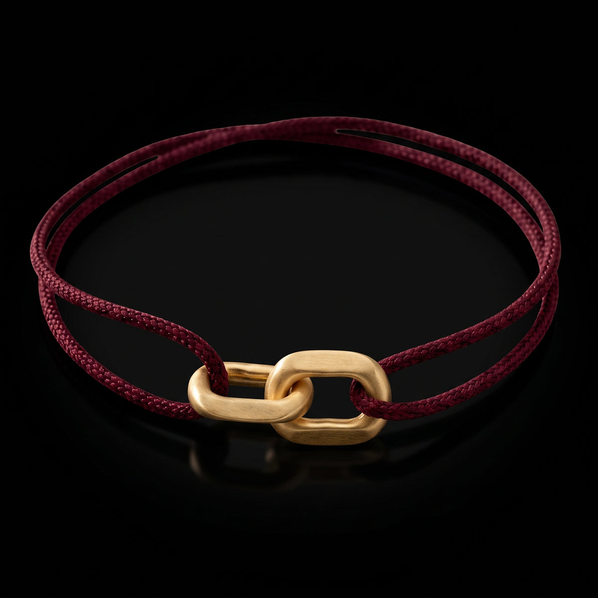 Link Bracelet in 14-karat solid gold on a burgundy woven cord, on black