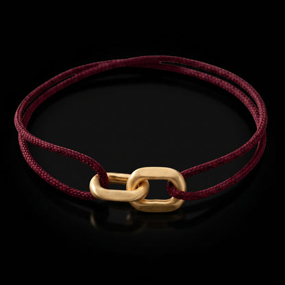 Link Bracelet in 14-karat solid gold on a burgundy woven cord, on black