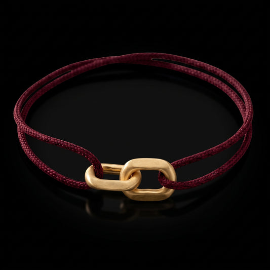 Link Bracelet in 14-karat solid gold on a burgundy woven cord, on black
